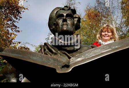 Portrait of the actress Inger Nilsson who played Astrid Lindgren's Pippi. Photographed at Djurgården in Stockholm. To the left the statue of Astrid Lindgren. Stock Photo