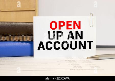 Closeup on businessman holding a card with OPEN UP AN ACCOUNT message, business concept image with soft focus background Stock Photo