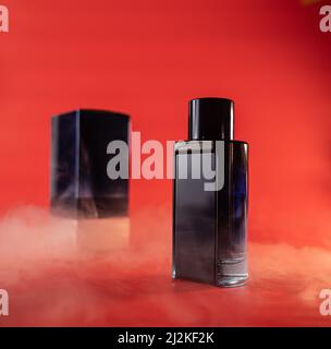 blue bottle of perfume water on a red background with smoke elements Stock Photo