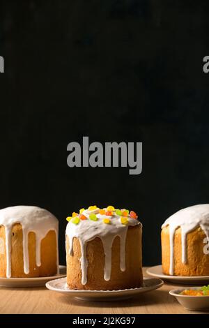 Three ruddy Easter cakes with white glaze on a dark background Stock Photo