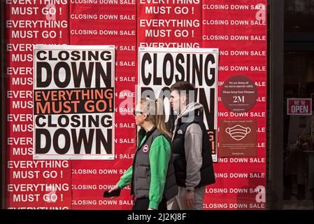 Couple walking by 'Closing Down', Everything Must Go' signs in the window of a shop on Princes Street, Edinburgh, Scotland, UK. Stock Photo
