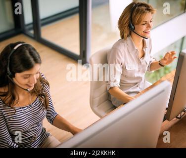 Theyre on the helpline. High angle shot of two attractive young women working in a call center. Stock Photo