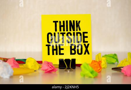 The phrase Think Outside the Box written in white chalk on a blackboard. Stock Photo