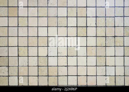 Beige ceramic mosaic square shape. Background of ceramic tiles. Ceramic tile with gray seams. Stock Photo
