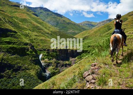 Horse riding in the outback. Shot of an attractive young woman riding a horse. Stock Photo