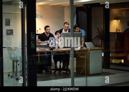 Late nights at the office. Shot of employees working in an office at night. Stock Photo