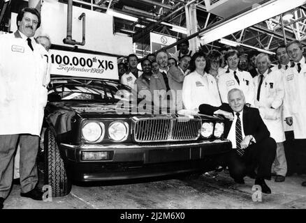 Jaguar Chairman and Chief Executive Sir John Egan at the front of the 100,000th XJ6 off the production line, surrounded by assembly worker. 11th September 1989. Stock Photo