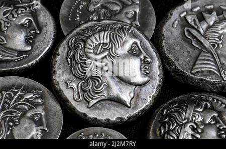 Ancient Greek coins close-up, portrait of Alexander the Great in center, silver tetradrachm coins. Concept of old rare money, valuable coins collectio Stock Photo