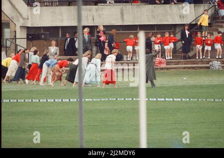 HRH The Princess of Wales, Princess Diana runs in her sons William and Harry's School Sports Day.  She is wearing the white top and long red skirt. The Princess came in 3rd.  In 1989 she came in 2nd and in 1988, she came in 1st.  None of her family this year won, with Charles coming in 12th out of 30 in the dads race, Harry not winning anything, and William taking a tumble in the novelty event.  Picture taken 12th June 1990 Stock Photo