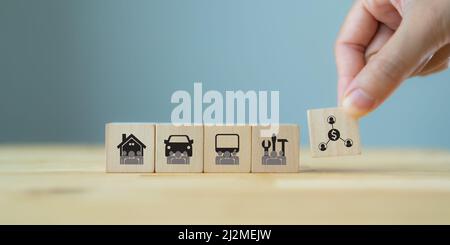 Sharing economy and smart consumption concept. People save money and share resources. Hand holds wooden cube with sharing symbol standing with car, ho Stock Photo