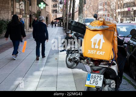 Madrid, Spain. 21st Feb, 2022. Pedesrians walk past a motorbike courier from the online food order and delivery service company, Just Eat, in Spain. (Credit Image: © Xavi Lopez/SOPA Images via ZUMA Press Wire) Stock Photo