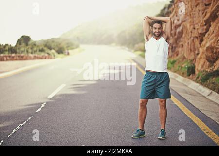 Im ready to run. Are you. Portrait of a young man stretching before going for a run. Stock Photo