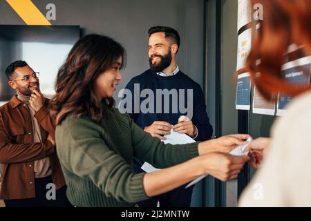 business colleagues analyzing some reports in an office. Group of multicultural businesspeople standing next to a glass wall in a modern boardroom. Yo Stock Photo