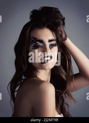 Makeup is art. Beauty is spirit. Studio shot of an attractive young woman wearing bold makeup. Stock Photo