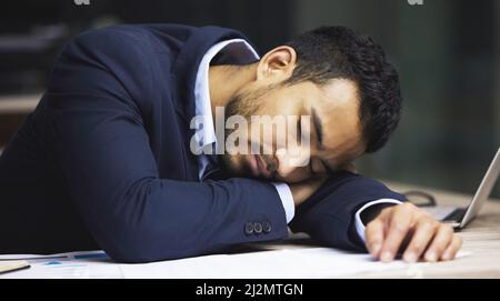 Ive finally hit a wall. Shot of a male stock broker having a nap at his desk. Stock Photo