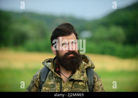 Middle aged farmer, closeup male farmer portrait. Portrait of middle aged bearded man, outdoors in meadow. Man portrait on farmland. Bearded hunter Stock Photo