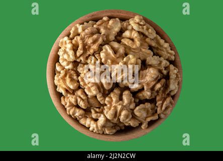 Bowl full of peeled walnuts on a green background,top view Stock Photo