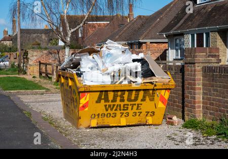 Metallic construction or building skip full up with building waste, in the UK. Stock Photo