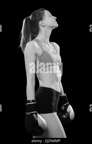 A Young Woman in Boxing Gloves Poses in a Fighting Stance and Looks at the  Camera. Attractive Female Boxer Ready To Stock Photo - Image of sport,  fighter: 253899504