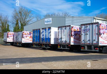 Transport trucks or lorries parked up in a line at an Express Food Service depot in an industrial estate in Rustington, West Sussex, England, UK. Stock Photo