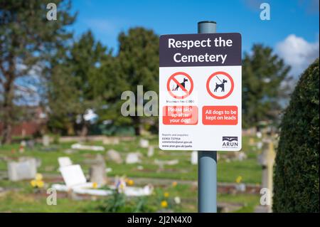 Sign at a cemetery asking people to respect the cemetery by keeping dogs under control on a lead and picking up their poo, in England, UK. Stock Photo