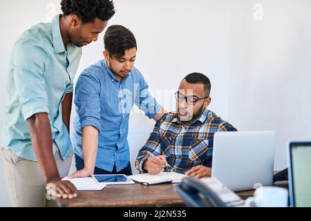 Hard work turns a startup into a success. Shot of a team of young entrepreneurs having a discussion in a modern office. Stock Photo