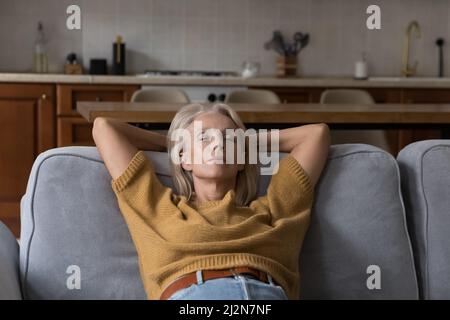 Calm elder lady relaxing with closed eyes on sofa Stock Photo