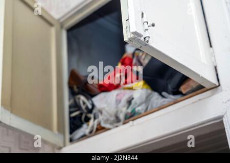 open doors of a pantry full of messy stuff, indoor shot Stock Photo
