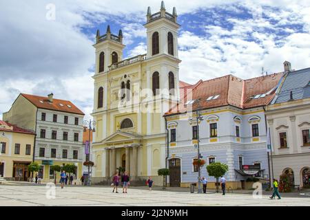 Banska Bystrica, Slovakia - August 17, 2021: view of SNP Square - colorful historic buildings, blooming flowers, green trees and people walking around Stock Photo