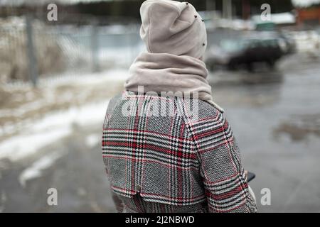 Girl in warm coat. Plaid coat and hat. Warm scarf on girl. Stock Photo