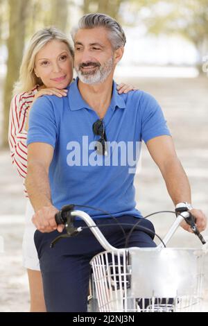 happy mature couple going for a bike ride Stock Photo