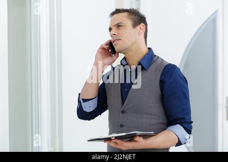 smiling male on the phone with clipboard Stock Photo
