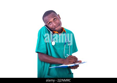 young doctor in uniform standing in hospital talking on cellphone and taking notes. Stock Photo