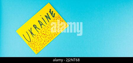 Yellow envelope with the inscription Ukraine on a blue background. Symbol of Ukraine's struggle for independence. Yellow envelope with red spots. Top Stock Photo