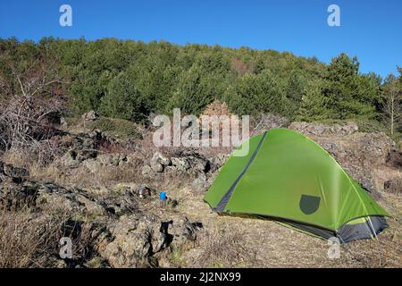 pinewood and green tent on glade of Etna National Park, Sicily Stock Photo