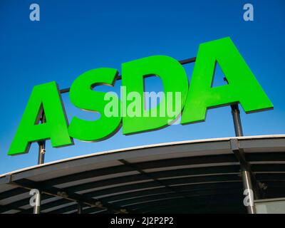 Corporate signage at a store of the ASDA British supermarket chain. Taken against a cloudless, blue sky on a sunny day. Stock Photo