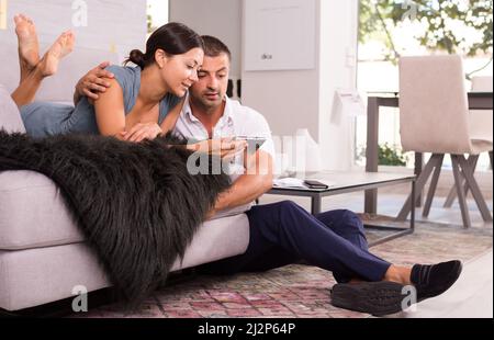 Happy woman with boyfriend using mobile phone Stock Photo