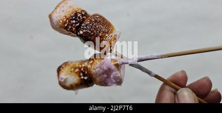 Evenly toasted marshmallows on skewer with burned texture on the surface. Ready to make marshmallow s'mores Stock Photo