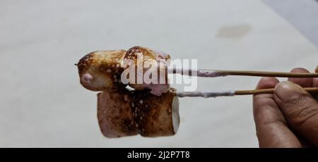 Evenly toasted marshmallows on skewer with burned texture on the surface. Ready to make marshmallow s'mores Stock Photo