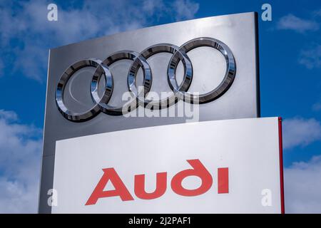 Helsinki / Finland - APRIL 3, 2022: Closeup of a signpost with Audi logo against a bright blue sky Stock Photo