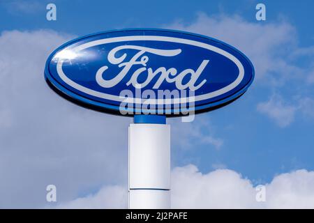 Helsinki / Finland - APRIL 3, 2022: Closeup of a signpost with Ford logo against a bright blue sky Stock Photo