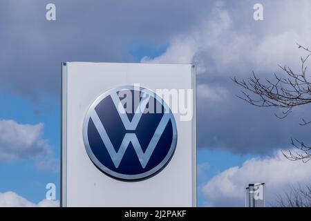 Helsinki / Finland - APRIL 3, 2022: Closeup of a signpost with Volkswagen logo against a bright blue sky Stock Photo