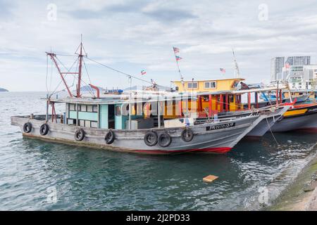 Kota Kinabalu, Malaysia - March 23, 2019: Fishing boats moored near KK Fish Market on a sunny day Stock Photo