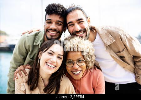 Group portrait of four multiracial united friends outdoors Stock Photo