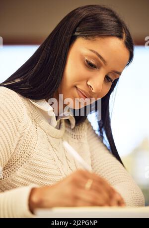 Making notes to come back to later. Cropped shot of an attractive young woman studying at home. Stock Photo