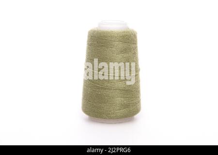 Green spool of thread isolated on white background. Skein of woolen threads. Yarn for knitting. Materials for sewing machine. Coil Stock Photo