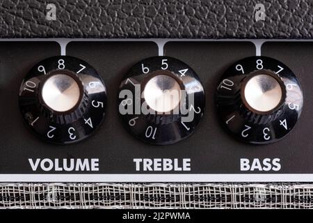 detail of the volume, treble and bass control knobs of a guitar amplifier, equalization dials close up, selective focus horizontal Stock Photo