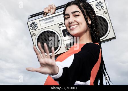 Dont stop me now. Cropped portrait of an attractive young female dancer standing with her boombox against a stormy backdrop. Stock Photo