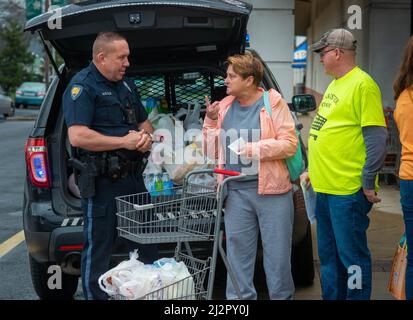 Warminster, United States. 03rd Apr, 2022. Warminster Police Officer Chris McCole (left) chats with Linda Morrow (center) and Brian Foedisch while loading donations into the police car during a food drive to help replenish the food shelves of Warminster Food Bank Sunday, April 03, 2022 at GIant in Warminster, Pennsylvania. Over 2300 pounds of food was donated along with gift cards and other items. (Photograph by Credit: William Thomas Cain/Alamy Live News Stock Photo