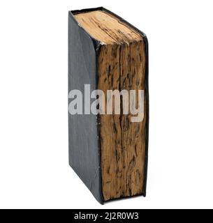 a very old book with burnt sheets and a black shabby cover on a white isolated background Stock Photo